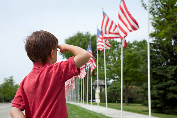 Young boy salutes flags
